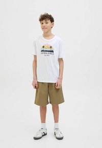 Valkoinen t-paita, jossa on värikäs palmutulostus ja "JACK & JONES" -teksti, yhdistettynä khaki-shortsit ja lenkkarit. Tyylikäs, rento muotoilu.