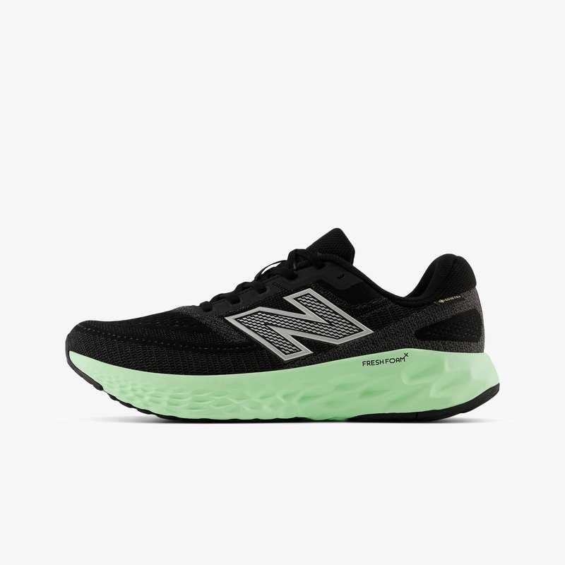 Zwarte hardloopschoenen met een mesh bovenkant, zilveren accenten en een gestructureerde mintgroene zool. Heeft een gevoerde middenzool en een vetersysteem.