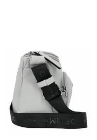 Borsa in pelle grigia dalla forma arrotondata, con chiusura a zip, tracolla nera regolabile con dettagli riflettenti e superficie texture.