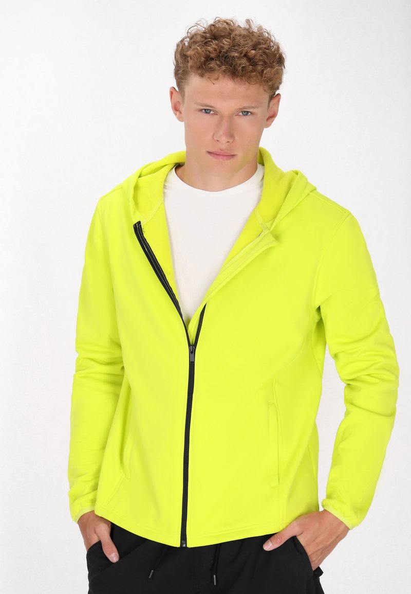 Neon gele zip-up hoodie met een getailleerd ontwerp, capuchon en zijzakken, voorzien van een contrasterende zwarte rits voor extra detail.