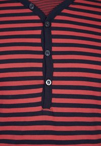 Gestreiftes Kurzarmhemd in Rot und Marineblau, mit V-Ausschnitt, drei Knöpfen und einem weichen Baumwollstoff mit glatter Textur.