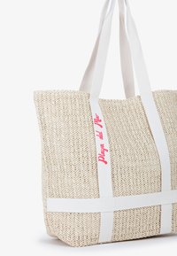 Borsa a mano intrecciata di un beige chiaro con manici in tessuto bianco e un logo rosso "Playa del Mar". Presenta un design a trama aperta e testurizzata.