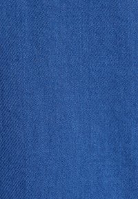 Tessuto blu testurizzato con un motivo a trama fitta, caratterizzato da diverse sfumature di blu, che creano un aspetto visivamente ricco e uniforme.