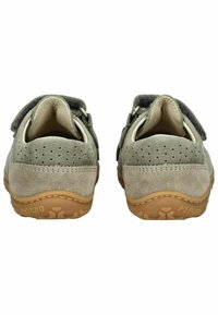 Zapatos infantiles de ante verde con una suave correa de textil gris, lados perforados y una suela de goma color marrón con patrones de tracción.