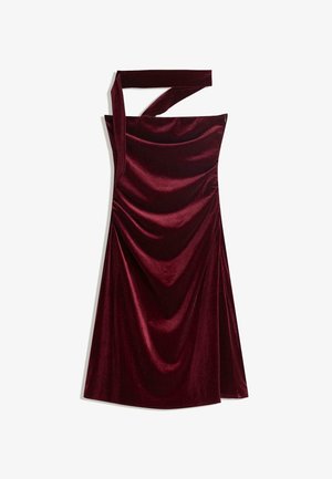Haljina bez rukava, s jednim ramenom, od burgundske baršuna s drapiranim materijalom i asimetričnim dekolteom.