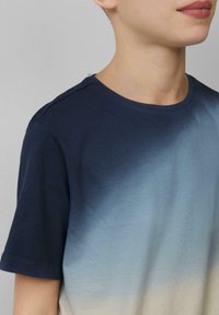 Baumwoll-T-Shirt mit einem Farbverlauf-Design, das von Marineblau zu Hellblau übergeht. Kurze Ärmel und Rundhalsausschnitt, glatte Textur mit dezenten Nähten.