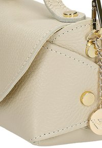 Beige Lederhandtasche mit strukturiertem Finish, metallic-goldenen Beschlägen, Druckknopfverschluss und einer dekorativen Kette mit einem Logo-Anhänger.