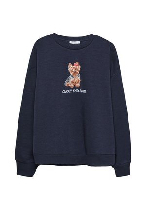 Sweatshirt bleu marine présentant un Yorkshire Terrier brodé avec un nœud rouge et le texte "CLASSY AND SASSY" en dessous du graphique. Texture douce.