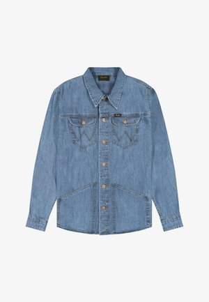 Világoskék farmerring, hosszú ujjakkal, hegyes gallérral, fém gombokkal az elején, valamint négy zsebbel, két mellkason és két alsó elülső zsebbel.