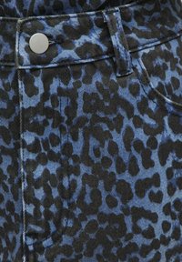 Blauw en zwart luipaardprint denim, met een gladde textuur, klassieke vijf-pocket ontwerp en een zilveren knop bij de taille.