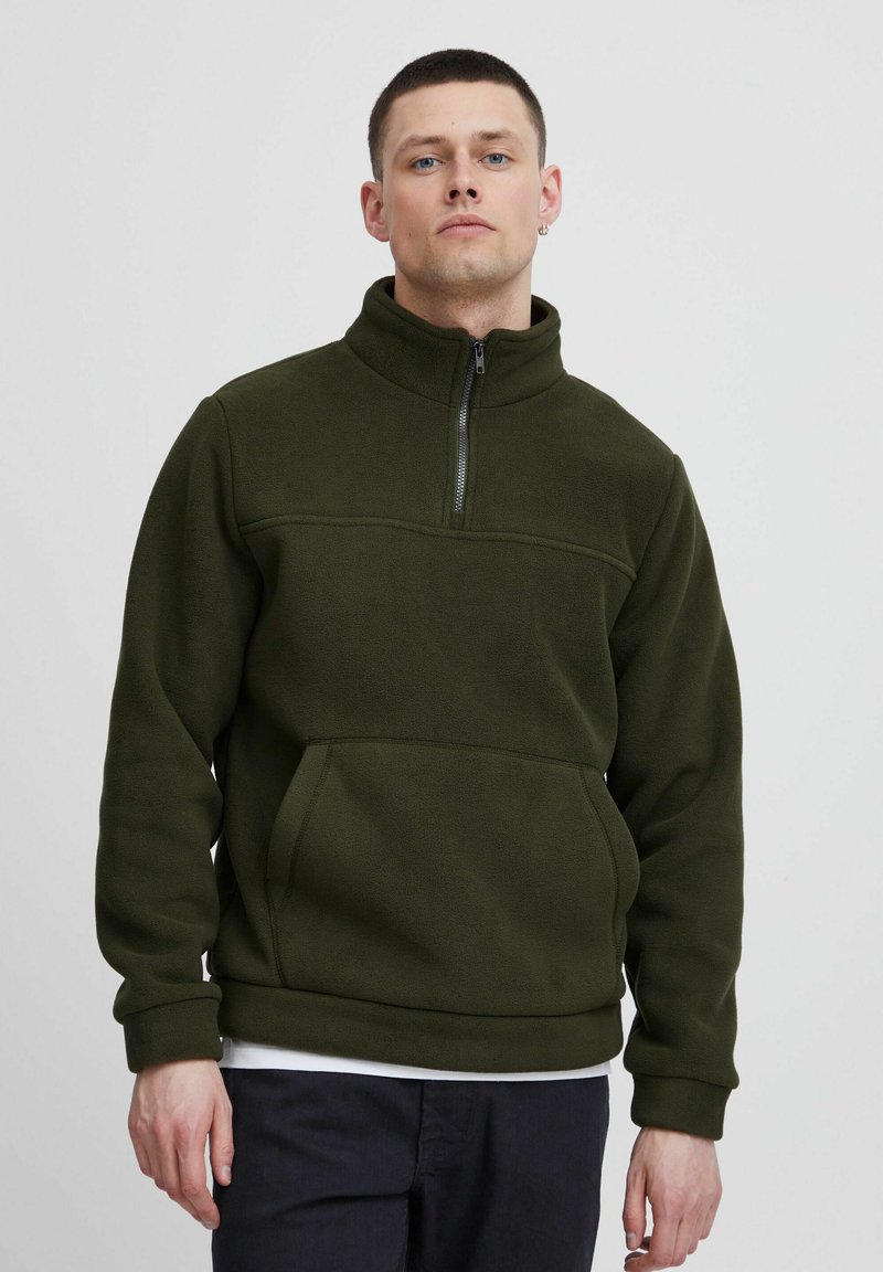 Mørkegrøn fleece pullover med høj krave, halvdels lynlås og kængurulomme; har tekstureret stof og ribbede manchetter.