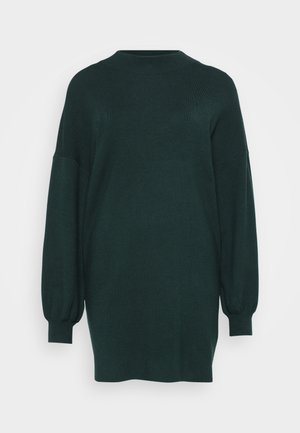 Donkergroen oversized sweater met een hoge hals, verlaagde schouders en lange, iets opgeblazen mouwen. Getextureerde brei stof.