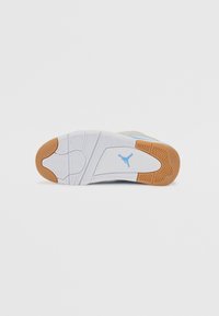 Semelle de chaussure de sport blanche et bleu clair avec des motifs texturés, des accents en caoutchouc gomme et un logo bleu au talon.