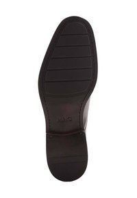 Semelle de chaussure noire avec des motifs de semelle rectangulaires, bords lisses et logo en relief "MNG" près du talon. Matériau en caoutchouc durable.