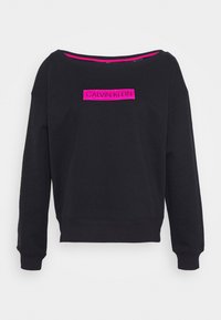 Sweat-shirt noir avec un large col, des manches longues, et un logo rectangulaire rose centré avec l'inscription "CALVIN KLEIN". Texture de tissu doux.
