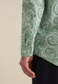 Camicia verde con motivo paisley, realizzata in tessuto leggero, con polsini a bottone e una vestibilità comoda. Design floreali bianchi notevoli in tutto il capo.