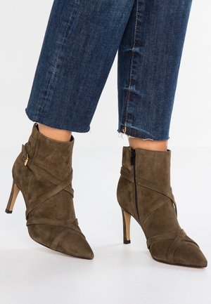 Brown suede ankle boots with a pointed toe, wraparound straps, and high heels. Features a side zip closure for easy wear.