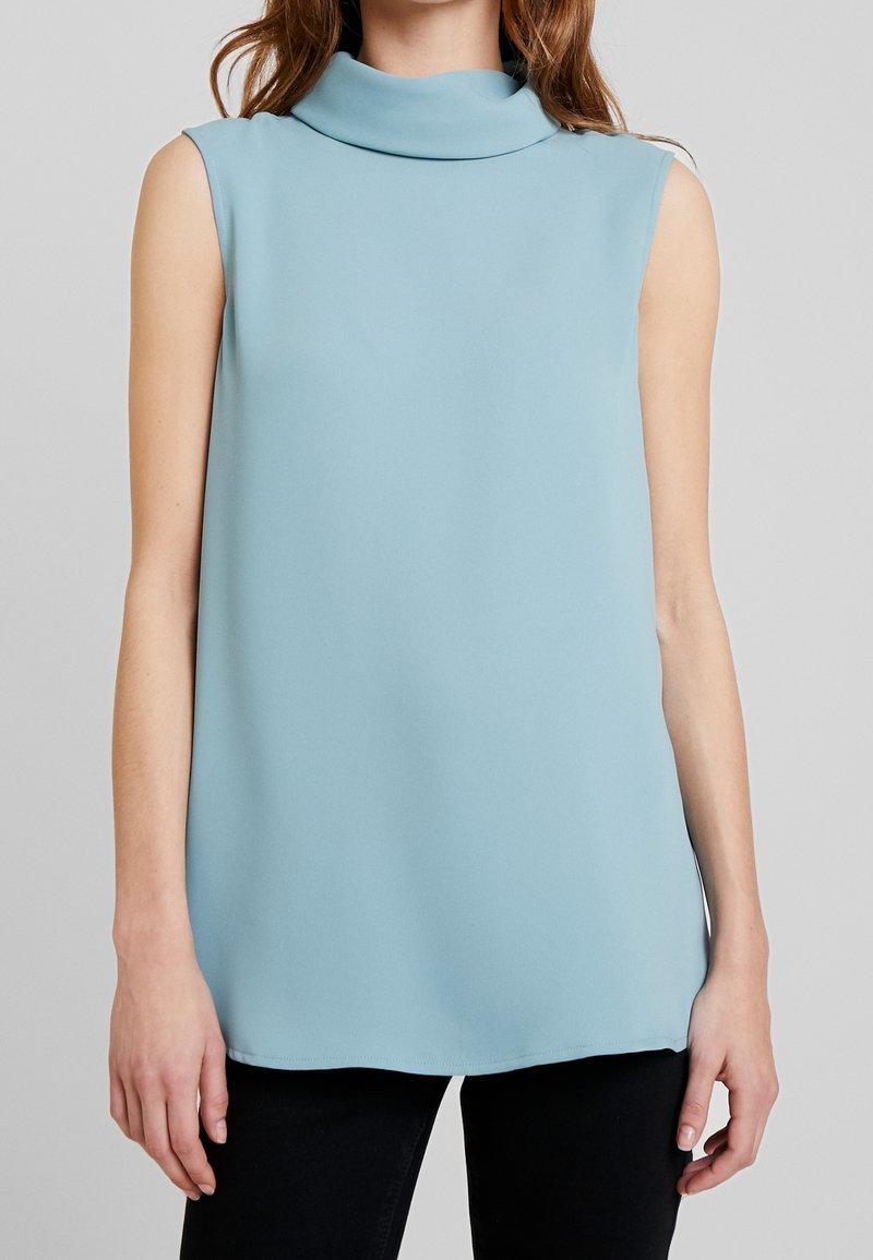 Ljust blå ärmlös topp med hög, veckad halsringning, tillverkad av slätt tyg, med en avslappnad silhuett och rak fåll.