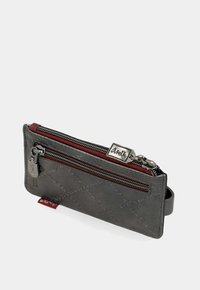 Portafoglio in pelle grigia sottile con due zip argentate, rivestimento in tessuto rosso, motivi cuciti e un piccolo bracciale laterale.
