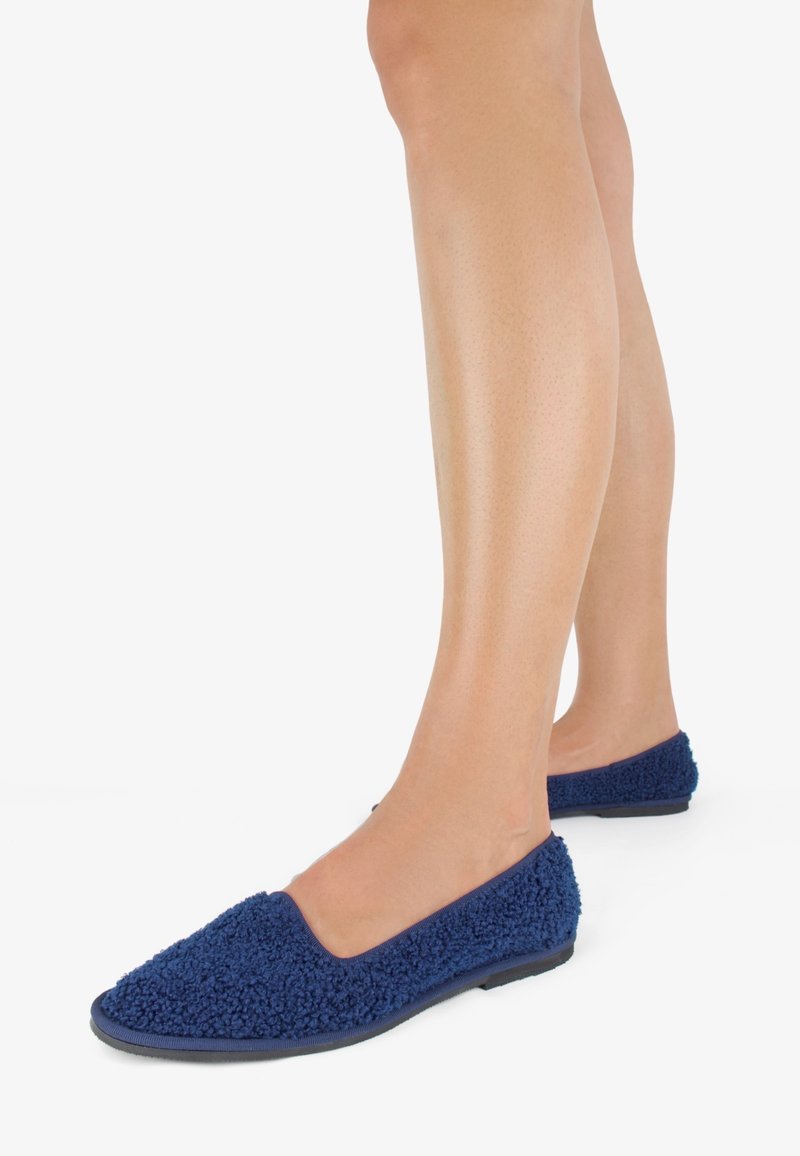 Scarpe slip-on blu navy realizzate con un materiale morbido, testurizzato e peloso. Presentano una punta arrotondata e una suola in gomma flessibile per il massimo comfort.