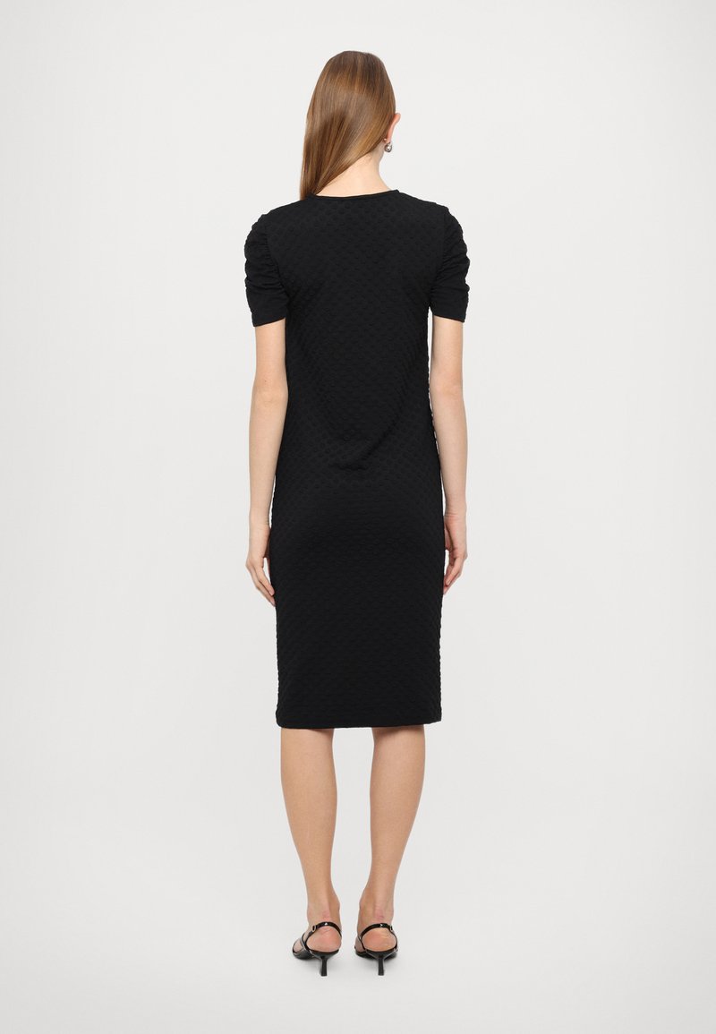 Vestido de punto negro con mangas cortas y abullonadas, y una silueta ajustada. Presenta una tela texturizada y un diseño hasta la rodilla.