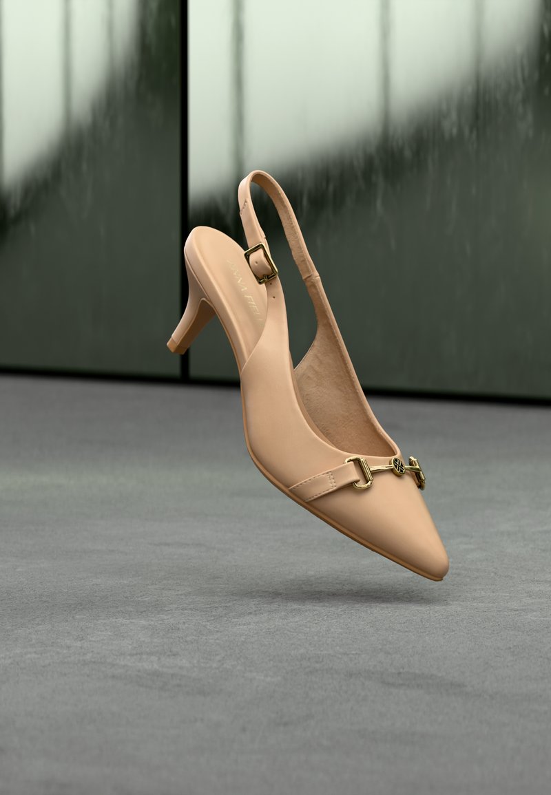 Escarpin slingback en cuir nude avec bout pointu, bride ajustable et détail en métal doré sur le dessus. Texture lisse et talon de 7,5 cm.