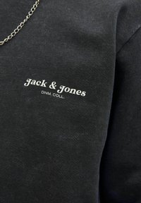 Schwarzer Baumwoll-Sweatshirt mit dem "Jack & Jones"-Logo in weißer Schrift. Kurzarm mit glatter Textur und schlichter Gestaltung.