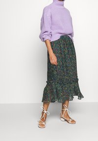 Neulettu laventelin värinen korkeakauluksinen villapaita, kukkakuosiset röyhelöhameet tummissa sävyissä ja valkeat narukengät, joissa on paksu korko.