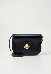 Schwarze Leder-Umhängetasche mit abgerundeter Form, Klappverschluss und einem goldenen, runden Schmuckakzent. Verfügt über einen dünnen, verstellbaren Riemen.