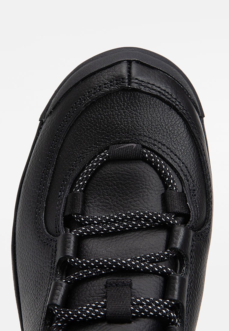 Chaussure en cuir noir à bout arrondi, dotée d'une surface texturée, de lacets à motif noir et blanc, et d'œillets rembourrés pour plus de confort.