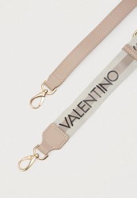 Leather strap in soft pink with a canvas center featuring "VALENTINO" in black lettering. Gold hardware clips on both ends for attachment.