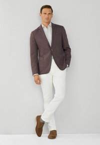 Blazer bordeaux, camicia chiara, pantaloni bianchi, scarpe in suede marroni; maniche arrotolate casual, chiusura a due bottoni, tasche laterali. Design semplice e moderno.