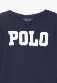 Mörk marinblå bomullscrewneck t-shirt med stora vita "POLO"-bokstäver över bröstet. Mjuk textur med klassisk passform.