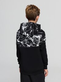 Czarna bluza z kapturem z białym abstrakcyjnym wzorem marmuru na górnej części pleców. Wykonana z miękkiego materiału, ma luźny krój i kaptur ze sznurkiem.