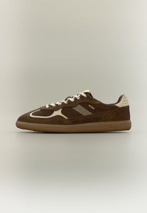 Brown suede low-top sneaker with cream accents, textured sole, white laces, and "ALOHA" branding on side and heel tab.