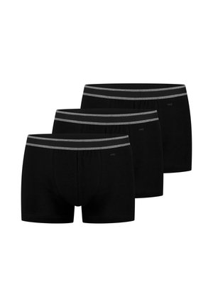 Tre sorte herreboxershorts med grå elastiske taljebånd arrangeret i en forskudt række på en hvid baggrund.