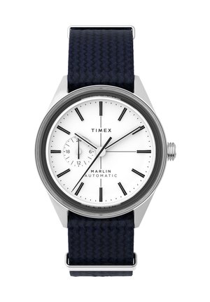 Die Timex Marlin automatische Uhr verfügt über ein weißes Zifferblatt mit schwarzen Stundenmarkierungen, ein Stahlgehäuse und ein dunkelblaues gewebtes Stoffarmband.