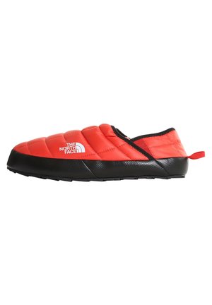Czerwone ocieplane buty wsuwane z czarną podeszwą i logo The North Face po boku, przeznaczone do użytku wewnątrz pomieszczeń lub na luźne, codzienne wyjścia na zewnątrz.