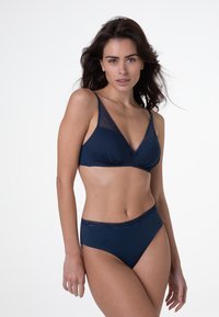 Set di lingerie blu navy composto da un reggiseno triangolare morbido con dettagli in pizzo e culotte a vita alta coordinate. Texture liscia e design minimal.