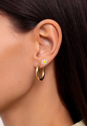 Orecchino a cerchio in oro con un perno floreale che presenta una margherita bianca e un centro giallo. Il design è elegante, con una texture lucida e liscia.