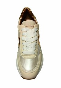 Beige leren sneaker met witte veters, metalen accenten en een ronde neus. Heeft een gladde textuur en eenvoudig ontwerp.
