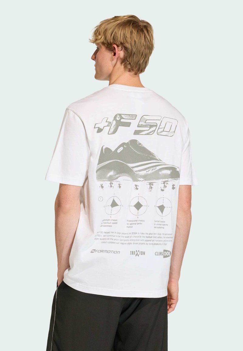 T-shirt bianca con un design grafico di una scarpa sul retro, con testo e diagrammi in grigio chiaro. Maniche corte e una vestibilità comoda.