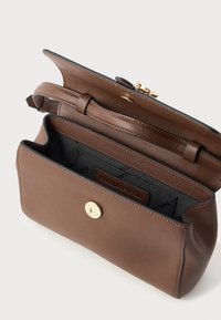 Brun lærcrossbody-veske med gullspenne, åpnet for å vise svart stoffinteriør og justerbar stroppdetalj.