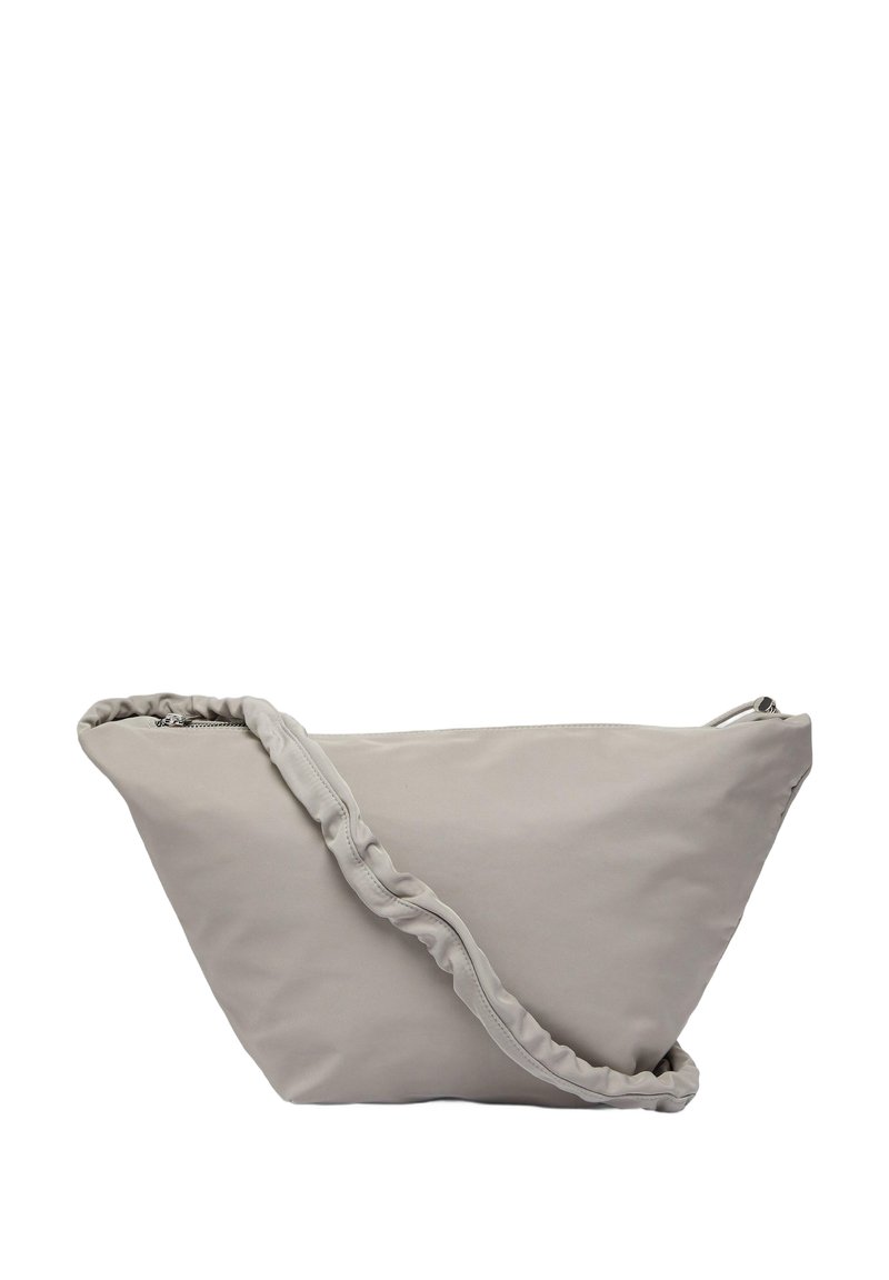Sac en tissu gris de forme triangulaire, avec une bandoulière froncée et une fermeture éclair. Texture douce et design minimaliste.