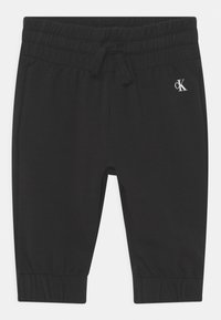 Pantaloni jogger neri in cotone con vita elasticizzata e cordoncino. Presentano orli a costine e un piccolo logo bianco sul davanti.