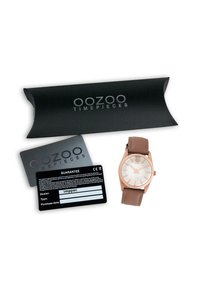 Rose gold wristwatch with a white dial, brown leather strap, and silver hour markers. Includes black guarantee card and packaging.
