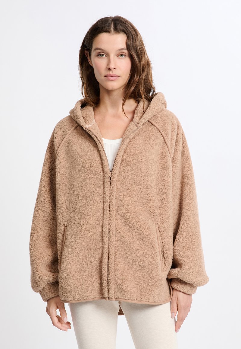 Felpa beige in pile, con zip frontale, maniche raglan, due tasche laterali, texture morbida, design con cappuccio, vestibilità rilassata e polsini a coste.