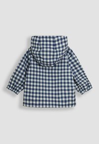 Impermeabile a scacchi blu navy e bianco con cappuccio, polsini elasticizzati e una texture liscia e lucida. Progettato per resistere all'acqua.