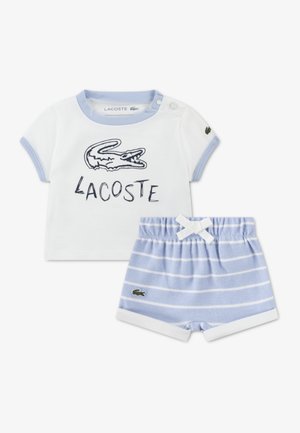 Lacoste toddler outfit featuring a white short-sleeve shirt with blue trim and a blue striped shorts, both with the Lacoste logo.