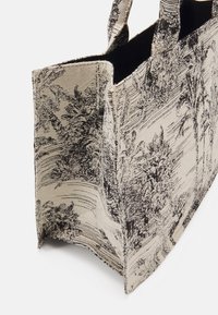 Torebka na ramię z czarno-białym nadrukiem palm na teksturowanej tkaninie; prostokątny kształt z krótkimi uchwytami i otwartym wierzchem.
